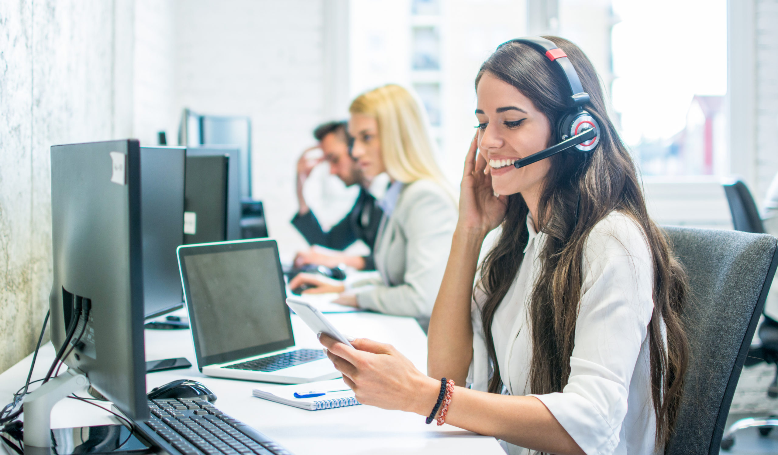 friendly-female-customer-support-operator-with-headset-using-phone-in